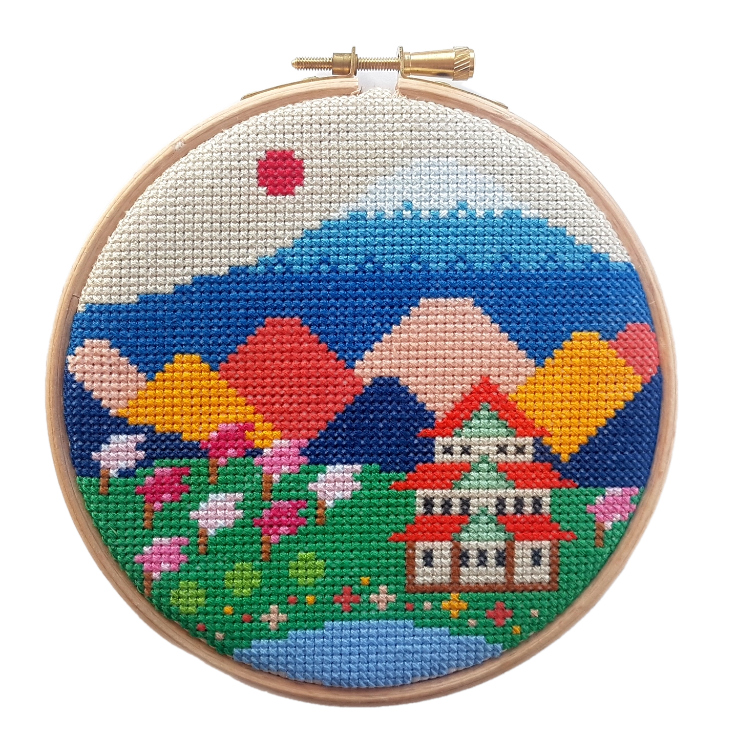 A cross stitch kit in a wooden hoop with a colourful image of Mount Fuji